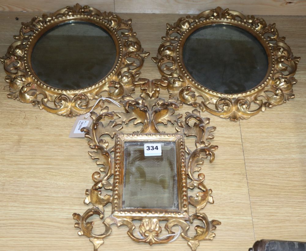 A pair of Venetian circular carved giltwood wall mirrors and another similar mirror